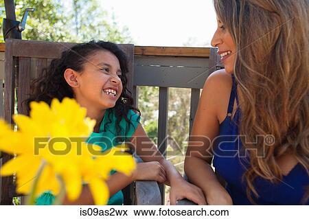 Mother and daughter on garden bench with yellow flower View Large Photo Image Stock Photo - Mother and daughter on garden bench with yellow flower. Fotosearch