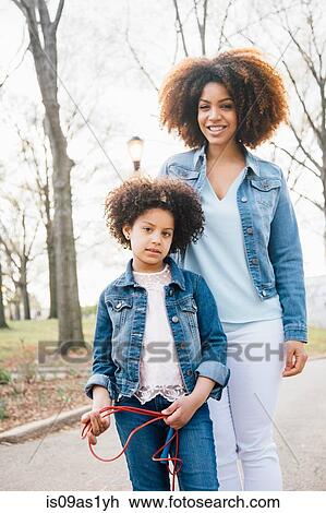Mother and daughter, standing side by side, looking at camera, smiling View Large Photo Image Stock Image - Mother and daughter, standing side by side, looking at camera, smiling. Fotosearch