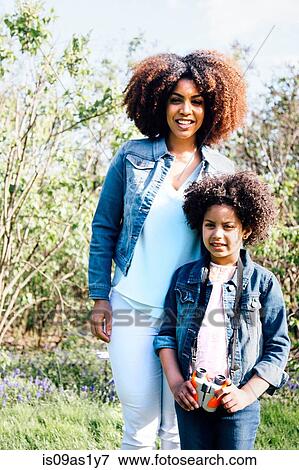 Mother and daughter, standing side by side, looking at camera, smiling View Large Photo Image Stock Photo - Mother and daughter, standing side by side, looking at camera, smiling. Fotosearch
