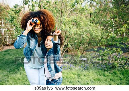 Mother and daughter using binoculars, looking up, pointing View Large Photo Image Stock Photography - Mother and daughter using binoculars, looking up, pointing. Fotosearch