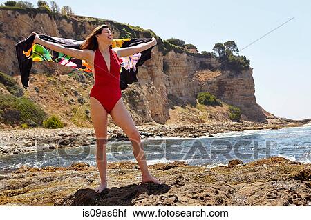 Portrait of mature woman wearing red bathing costume posing with sarong at coast View Large Photo Image Stock Image - Portrait of mature woman wearing red bathing costume posing with sarong at coast. Fotosearch