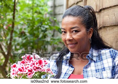 Portrait of mature woman with bunch of pink flowers in garden View Large Photo Image Stock Image - Portrait of mature woman with bunch of pink flowers in garden. Fotosearch