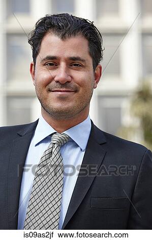 Stock Image - Portrait of mid adult business man, looking at camera, smiling. Fotosearch