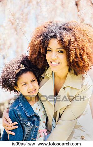 Portrait of mother with arm around daughter, looking at camera, smiling View Large Photo Image Stock Photo - Portrait of mother with arm around daughter, looking at camera, smiling. Fotosearch