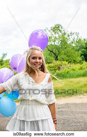 Portrait of pretty young woman with bunch of balloons on rural road View Large Photo Image Stock Image - Portrait of pretty young woman with bunch of balloons on rural road. Fotosearch