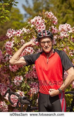 Picture - Portrait of senior man, flexing muscles, ready to use bicycle. Fotosearch