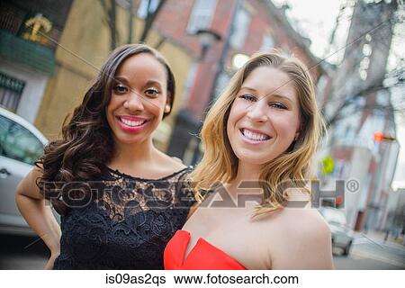 Stock Photograph - Portrait of two glamorous young adult female friends on street. Fotosearch