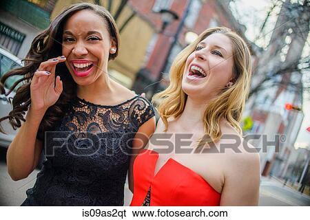 Portrait of two glamorous young adult female friends laughing on street View Large Photo Image Stock Photograph - Portrait of two glamorous young adult female friends laughing on street. Fotosearch