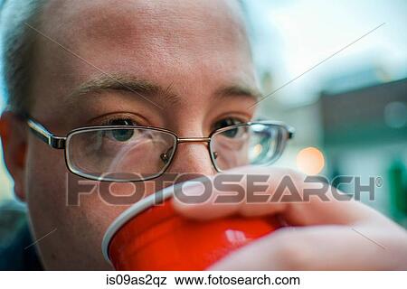 Portrait of young man drinking from takeaway cup on street View Large Photo Image Stock Photo - Portrait of young man drinking from takeaway cup on street. Fotosearch