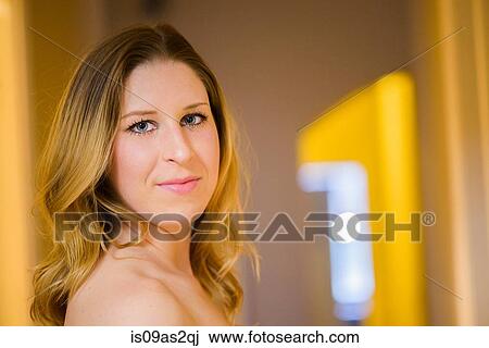 Stock Image - Portrait of young woman in hallway. Fotosearch