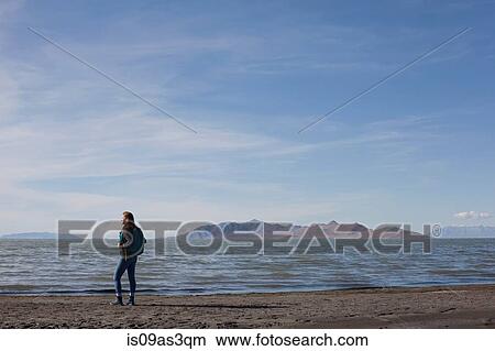 Rear view of young woman standing at waters edge looking out, Great Salt lake, Utah, USA View Large Photo Image Picture - Rear view of young woman standing at waters edge looking out, Great Salt lake, Utah, USA. Fotosearch