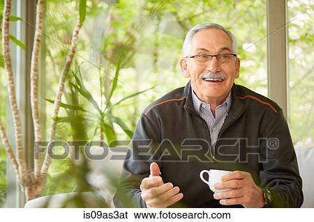 Stock Photograph - Senior man at home, drinking coffee. Fotosearch