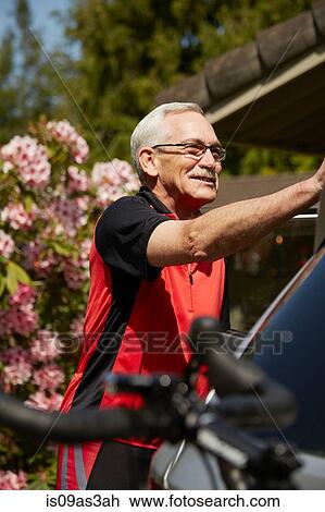 Senior man attaching bicycle to car View Large Photo Image Stock Image - Senior man attaching bicycle to car. Fotosearch