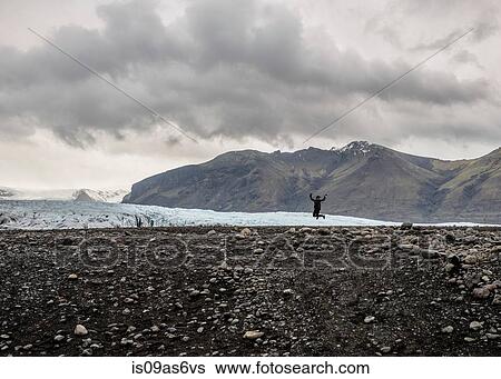 Silhouette of female tourist jumping mid air in front of glacier, Skaftafell, Iceland View Large Photo Image Stock Photograph - Silhouette of female tourist jumping mid air in front of glacier, Skaftafell, Iceland. Fotosearch