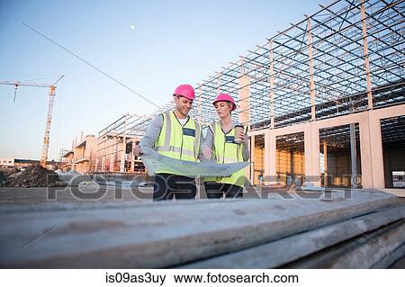 Surveyor and architect looking at blueprint on construction site View Large Photo Image Stock Photo - Surveyor and architect looking at blueprint on construction site. Fotosearch