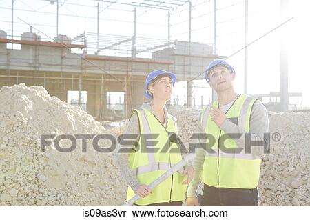 Surveyor and architect looking up from construction site View Large Photo Image Stock Photography - Surveyor and architect looking up from construction site. Fotosearch