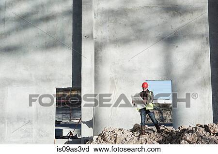 Surveyor reviewing blueprint on construction site View Large Photo Image Stock Image - Surveyor reviewing blueprint on construction site. Fotosearch