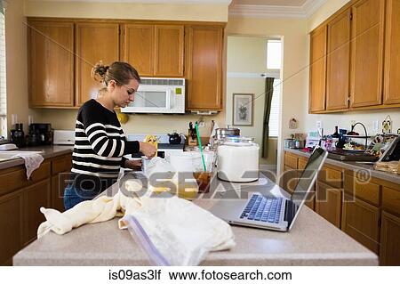 Stock Image - Woman baking in kitchen. Fotosearch