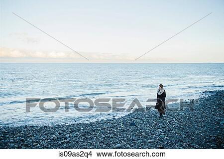 Picture - Woman strolling on beach. Fotosearch