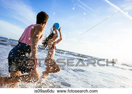 Stock Photograph - Young couple fooling around in sea. Fotosearch