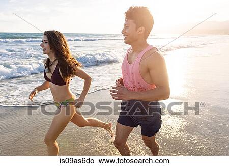 Young couple on running along beach View Large Photo Image Picture - Young couple on running along beach. Fotosearch