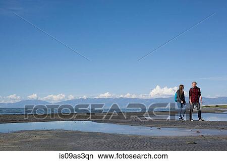 Picture - Young couple walking, looking at each other, Great Salt Lake, Utah, USA. Fotosearch