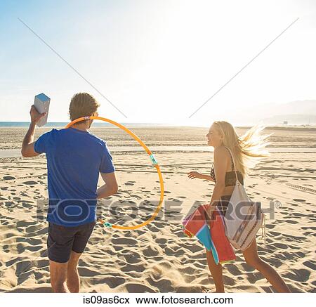 Young couple walking on beach, rear view View Large Photo Image Stock Photo - Young couple walking on beach, rear view. Fotosearch