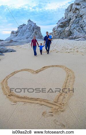 Young family walking on beach, heart shape in foreground View Large Photo Image Stock Photo - Young family walking on beach, heart shape in foreground. Fotosearch