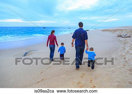 Young family walking on beach, rear view View Large Photo Image Stock Image - Young family walking on beach, rear view. Fotosearch