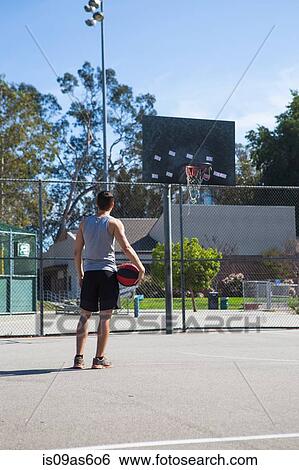 Young male basketball player looking at basketball hoop View Large Photo Image Stock Photograph - Young male basketball player looking at basketball hoop. Fotosearch