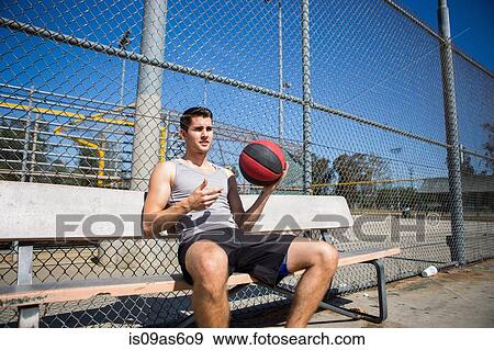 Young male basketball player taking a break on bench View Large Photo Image Stock Photo - Young male basketball player taking a break on bench. Fotosearch