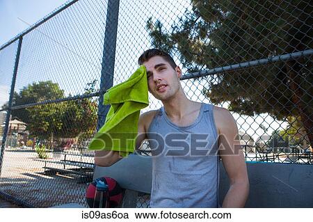 Young male basketball player wiping brow with towel View Large Photo Image Stock Image - Young male basketball player wiping brow with towel. Fotosearch