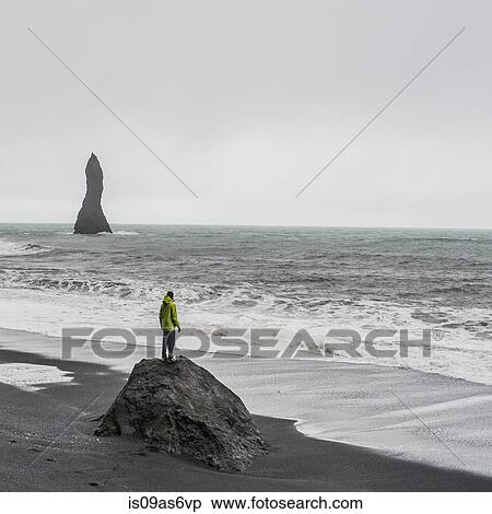 Young male tourist looking out to sea from rock formation, Reynisfjara, Iceland View Large Photo Image Stock Photography - Young male tourist looking out to sea from rock formation, Reynisfjara, Iceland. Fotosearch