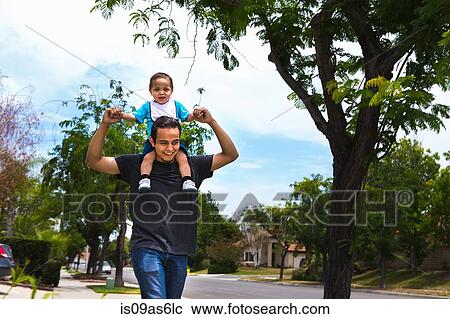 Young man carrying toddler brother on shoulders along suburban sidewalk View Large Photo Image Stock Image - Young man carrying toddler brother on shoulders along suburban sidewalk. Fotosearch