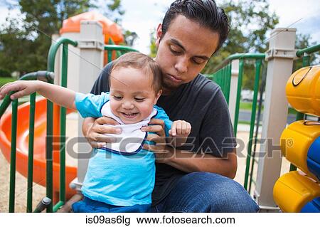 Young man guiding toddler brother on playground slide View Large Photo Image Stock Image - Young man guiding toddler brother on playground slide. Fotosearch