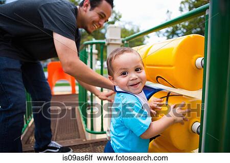 Young man playing with toddler brother on playground equipment View Large Photo Image Stock Image - Young man playing with toddler brother on playground equipment. Fotosearch