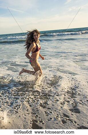 Young woman running in sea View Large Photo Image Stock Photograph - Young woman running in sea. Fotosearch
