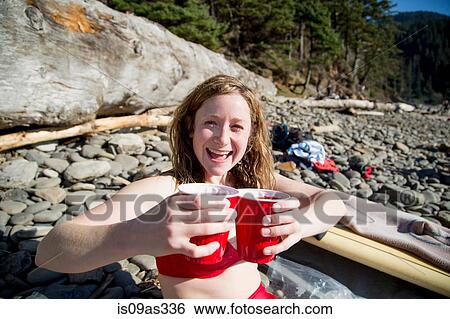Young woman sitting on rocky beach, holding drinks, smiling, Short Sands Beach, Oregon, USA View Large Photo Image Stock Photograph - Young woman sitting on rocky beach, holding drinks, smiling, Short Sands Beach, Oregon, USA. Fotosearch