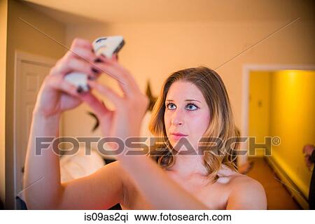 Young woman taking smartphone selfie in hallway View Large Photo Image Stock Image - Young woman taking smartphone selfie in hallway. Fotosearch