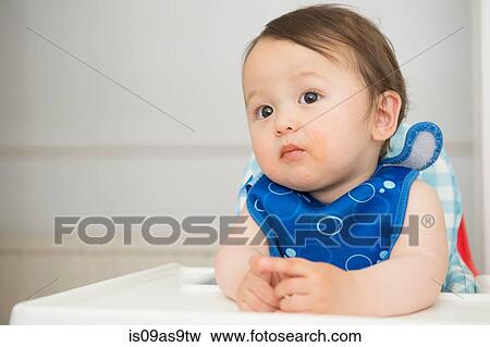 Baby boy watching from kitchen high chair View Large Photo Image Stock Photo - Baby boy watching from kitchen high chair. Fotosearch