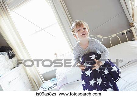 Boy on bed holding behind navy blue star patterned woollen blanket View Large Photo Image Stock Photograph - Boy on bed holding behind navy blue star patterned woollen blanket. Fotosearch