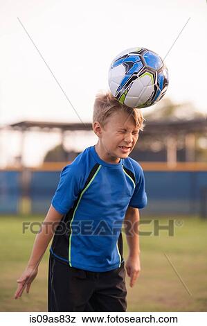 Boy with eyes closed heading football on practice pitch View Large Photo Image Stock Photo - Boy with eyes closed heading football on practice pitch. Fotosearch