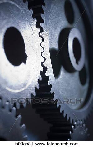 Stock Image - Close up of light shining on metal cogs. Fotosearch
