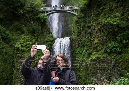 Stock Photo - Couple taking selfie with dog, Multnomah Falls, Oregon, USA. Fotosearch