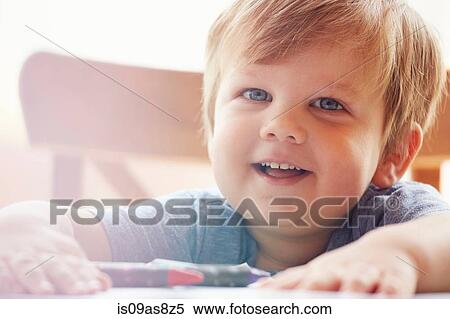 Cropped view of boy with hands on table, looking at camera smiling View Large Photo Image Stock Photography - Cropped view of boy with hands on table, looking at camera smiling. Fotosearch