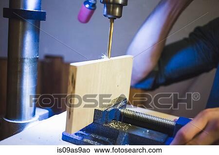 Cropped view of young mans hands opearting drill on wood in clamp View Large Photo Image Picture - Cropped view of young mans hands opearting drill on wood in clamp. Fotosearch