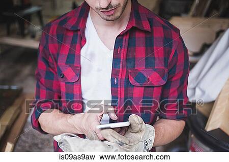 Cropped view of young mans hands wearing protective gloves using smartphone View Large Photo Image Stock Photo - Cropped view of young mans hands wearing protective gloves using smartphone. Fotosearch