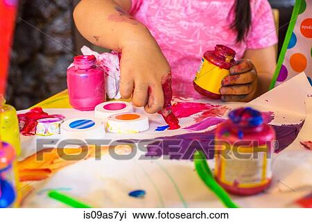 Girl sitting at table, making art, using paint, focus on artwork View Large Photo Image Stock Image - Girl sitting at table, making art, using paint, focus on artwork. Fotosearch