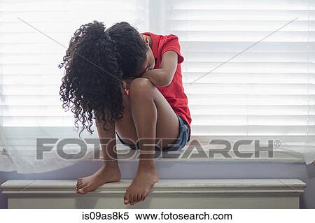 Girl sitting on windowsill looking sad with head on knees View Large Photo Image Stock Photography - Girl sitting on windowsill looking sad with head on knees. Fotosearch