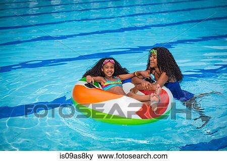 Girls in swimming pool playing with inflatable ring, smiling View Large Photo Image Stock Photo - Girls in swimming pool playing with inflatable ring, smiling. Fotosearch